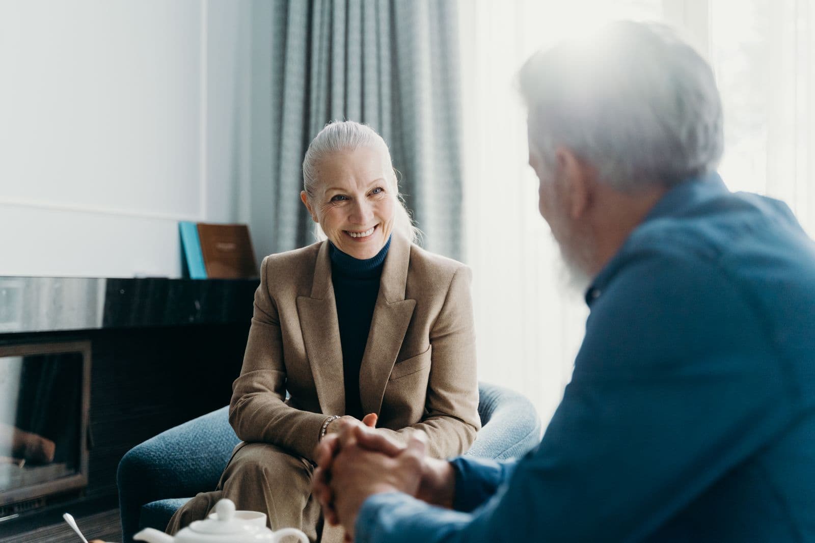 A caregiver and an elderly client sharing a warm conversation at home