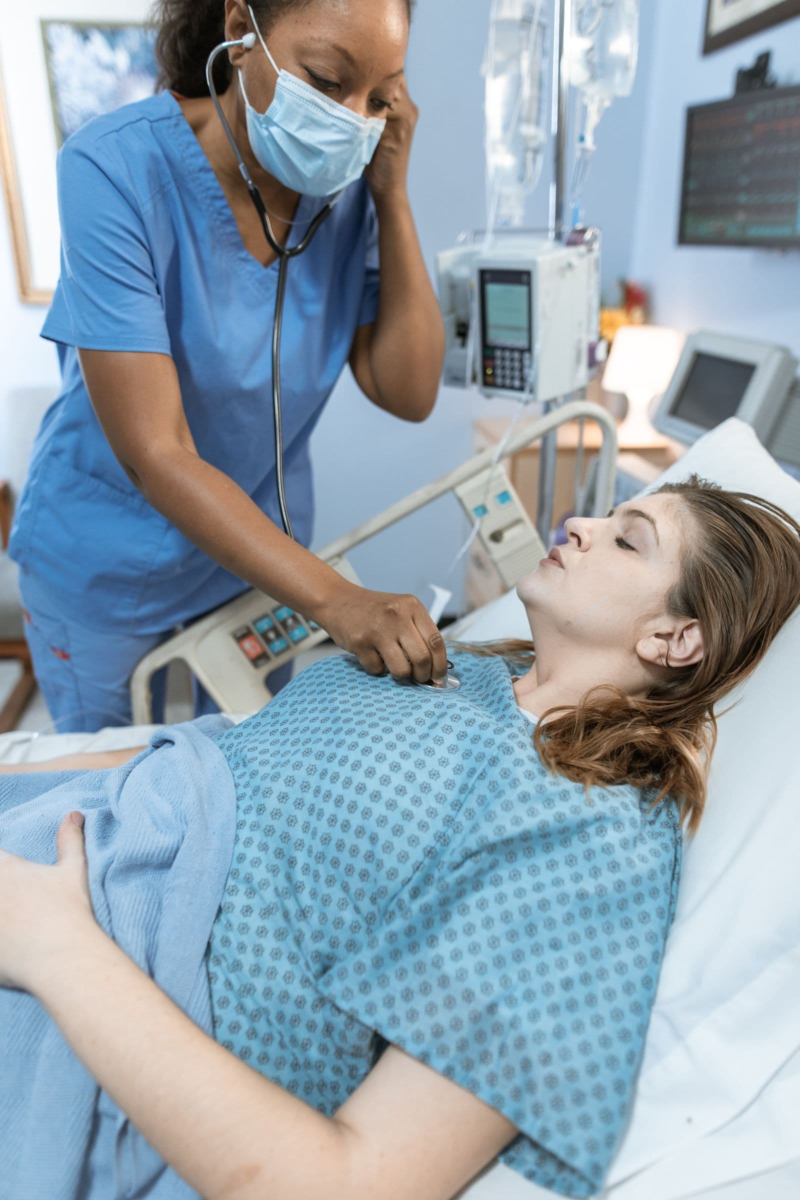 A healthcare professional attentively checking on a resting patient