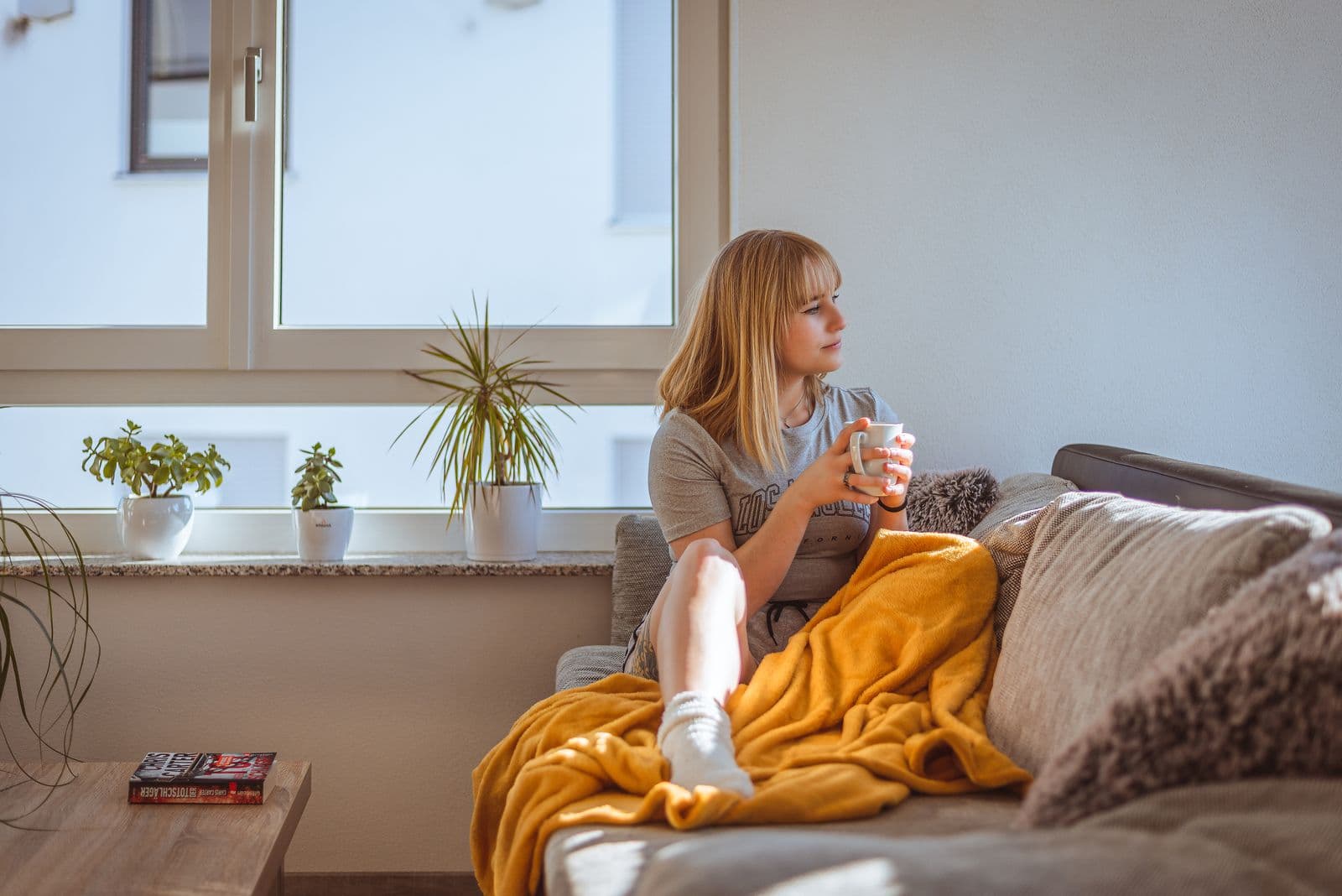 A woman relaxing peacefully on a sofa with a cup of coffee, taking a well-earned break