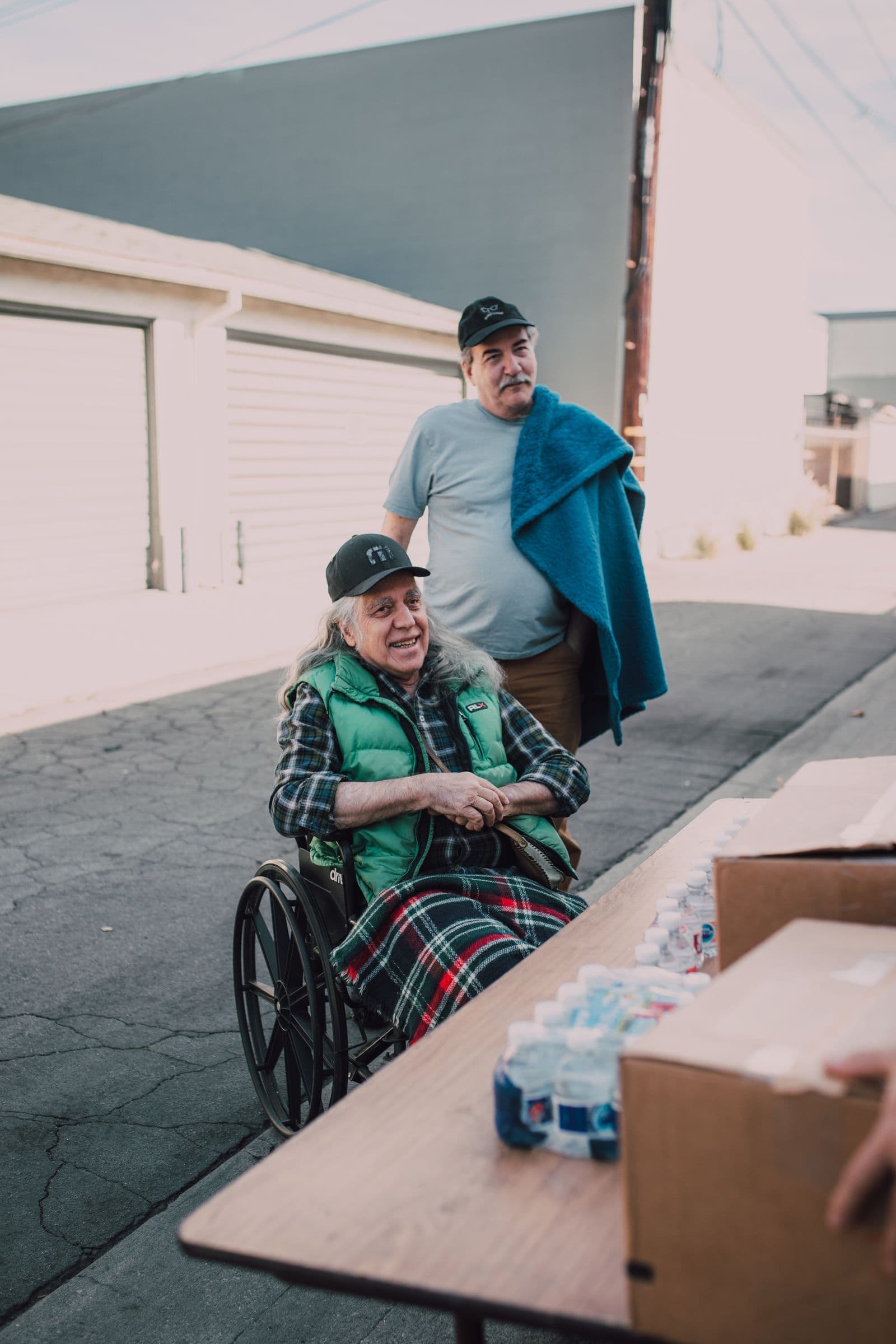 A caregiver providing attentive support to someone using a wheelchair during recovery